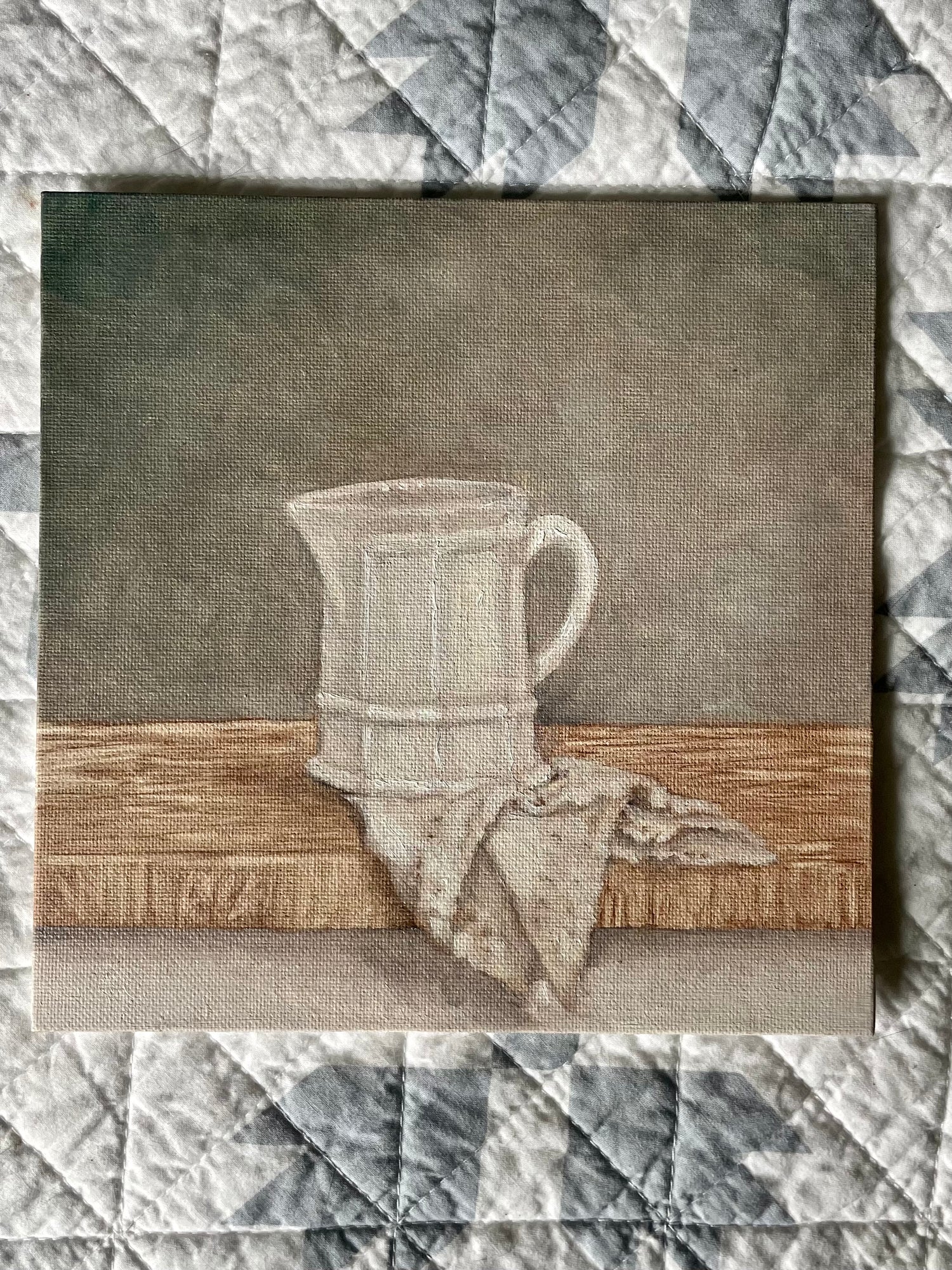 Be Still Collection, White Ironstone Cream Pitcher w/antique napkin on a soft wooden surface